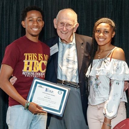 BraddockWithStudents G. Holmes Braddock smiles with two scholarship recipients.