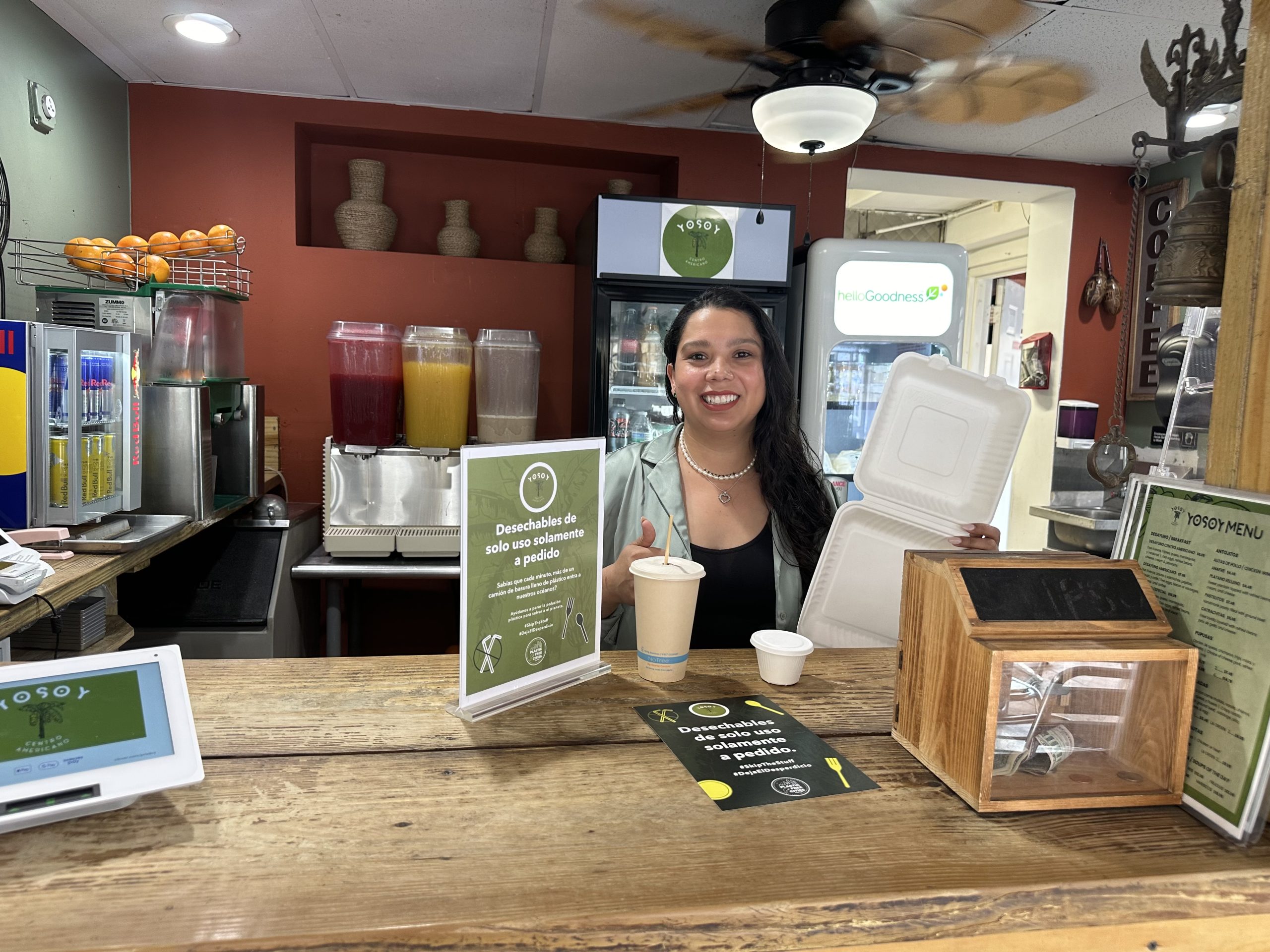 Woman smiles behind the counter of a plastic-free cafe