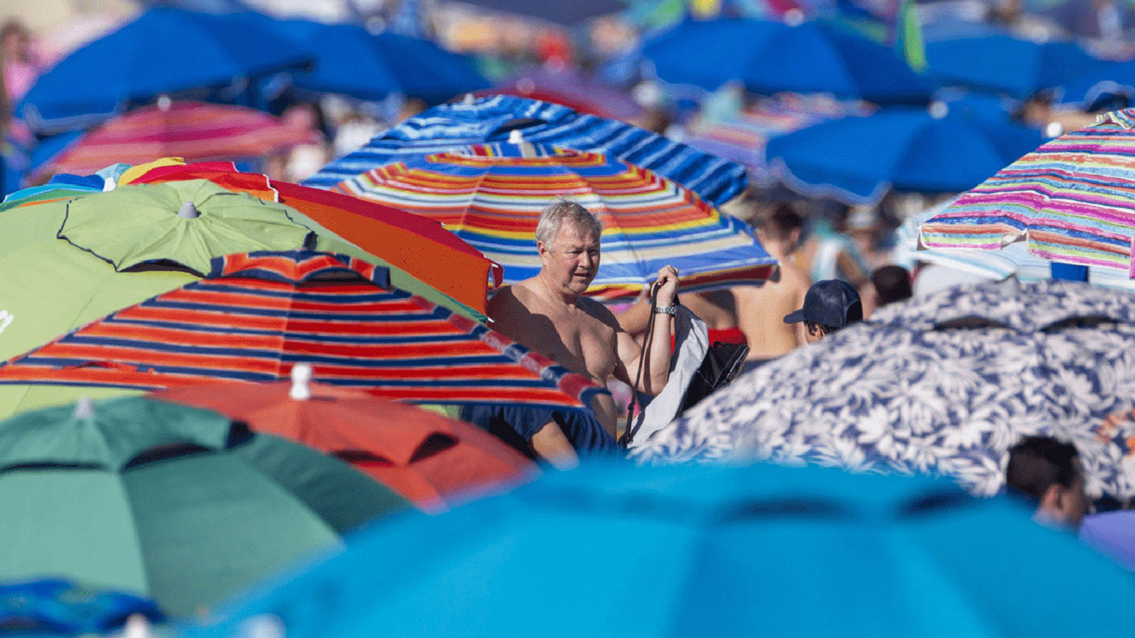 Man standing amid many beach umbrellas | The Miami Foundation