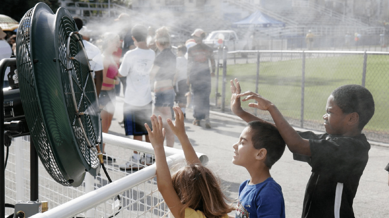 Kids playing with a misting fan | Extreme Heat Protection