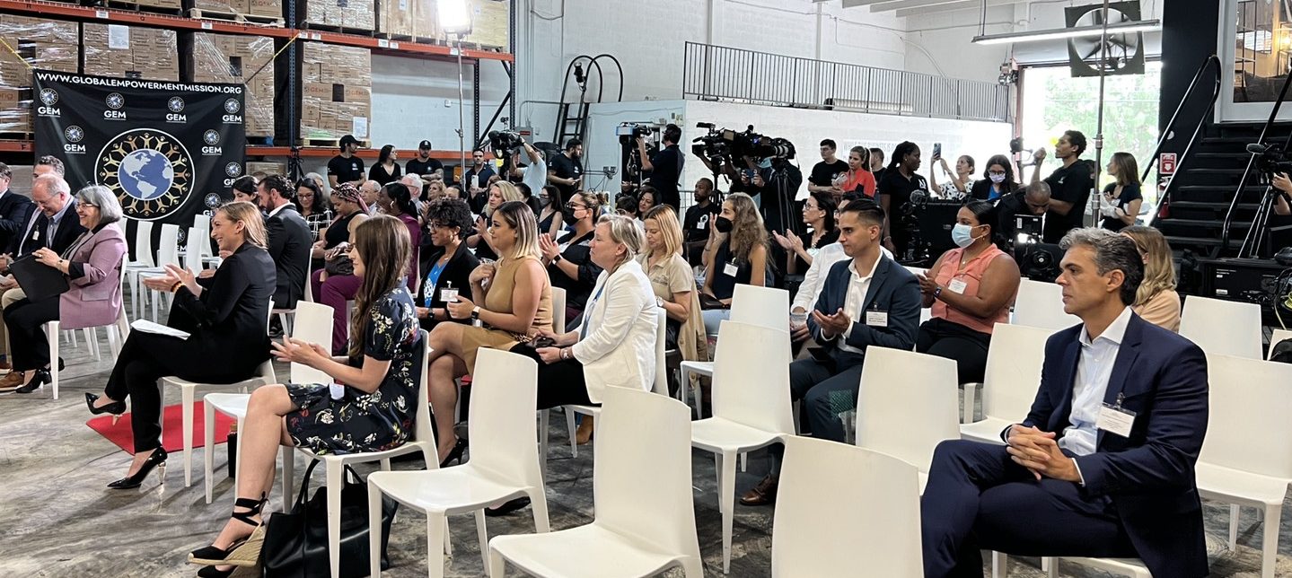Crowd sitting in white chairs