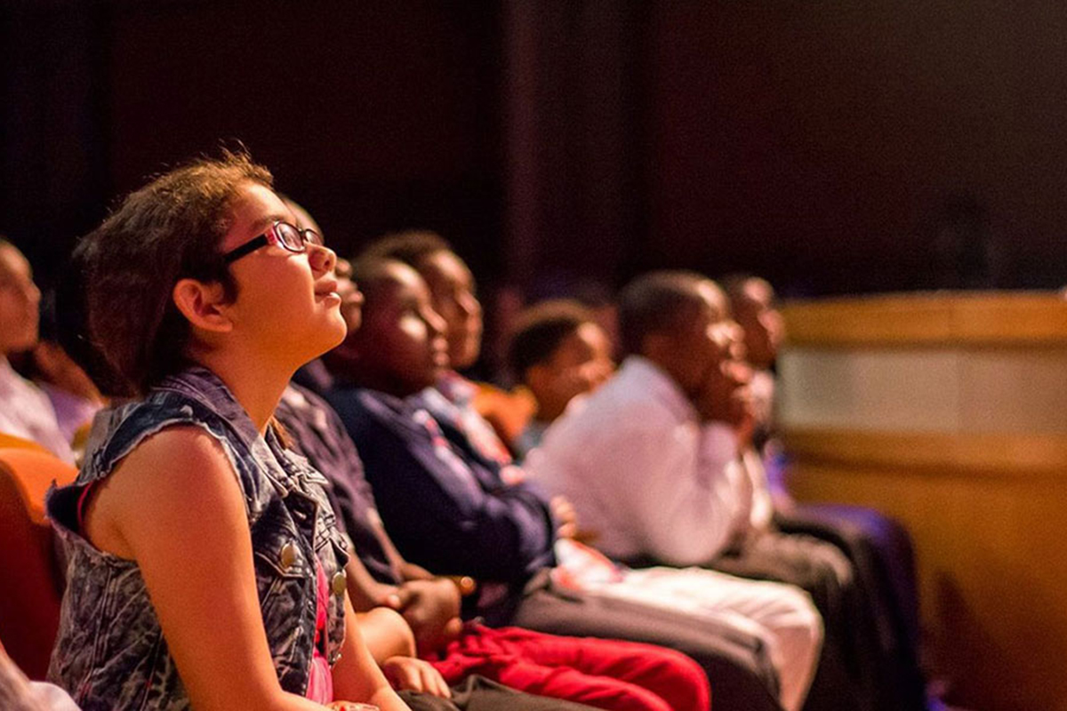 Gente en un teatro mirando al escenario | The Miami Foundation