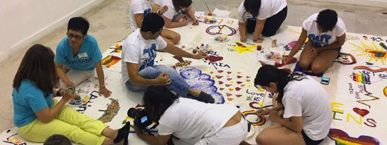 People painting on a large mural | 2017 GLBT Community Projects Fund Recipients