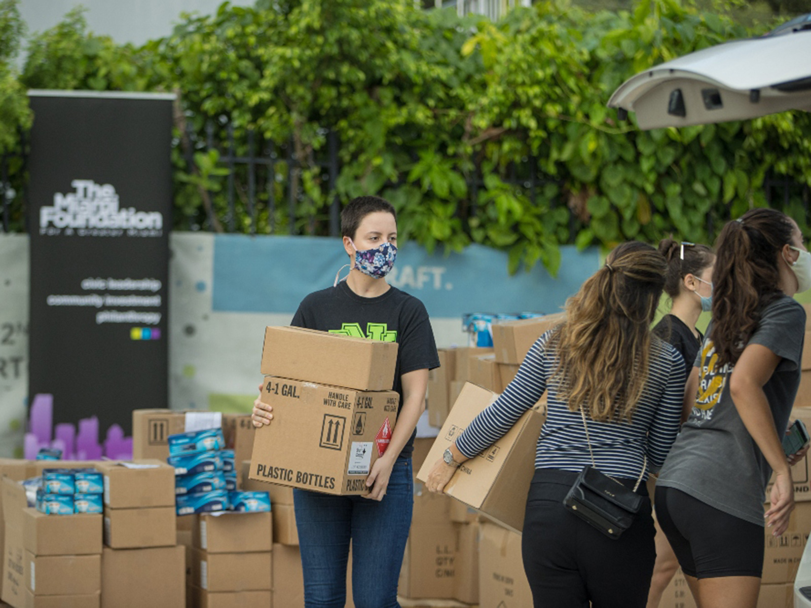People moving boxes while wearing masks
