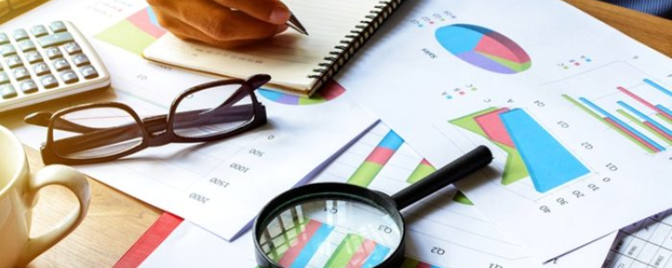 Data sheets, glasses, a notebook, and magnifying glass