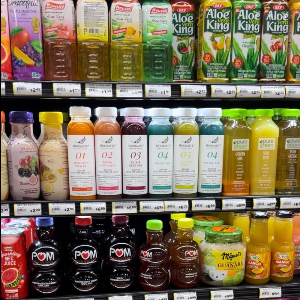 Colorful bottles of fruit juices on a well-lit grocery shelf.