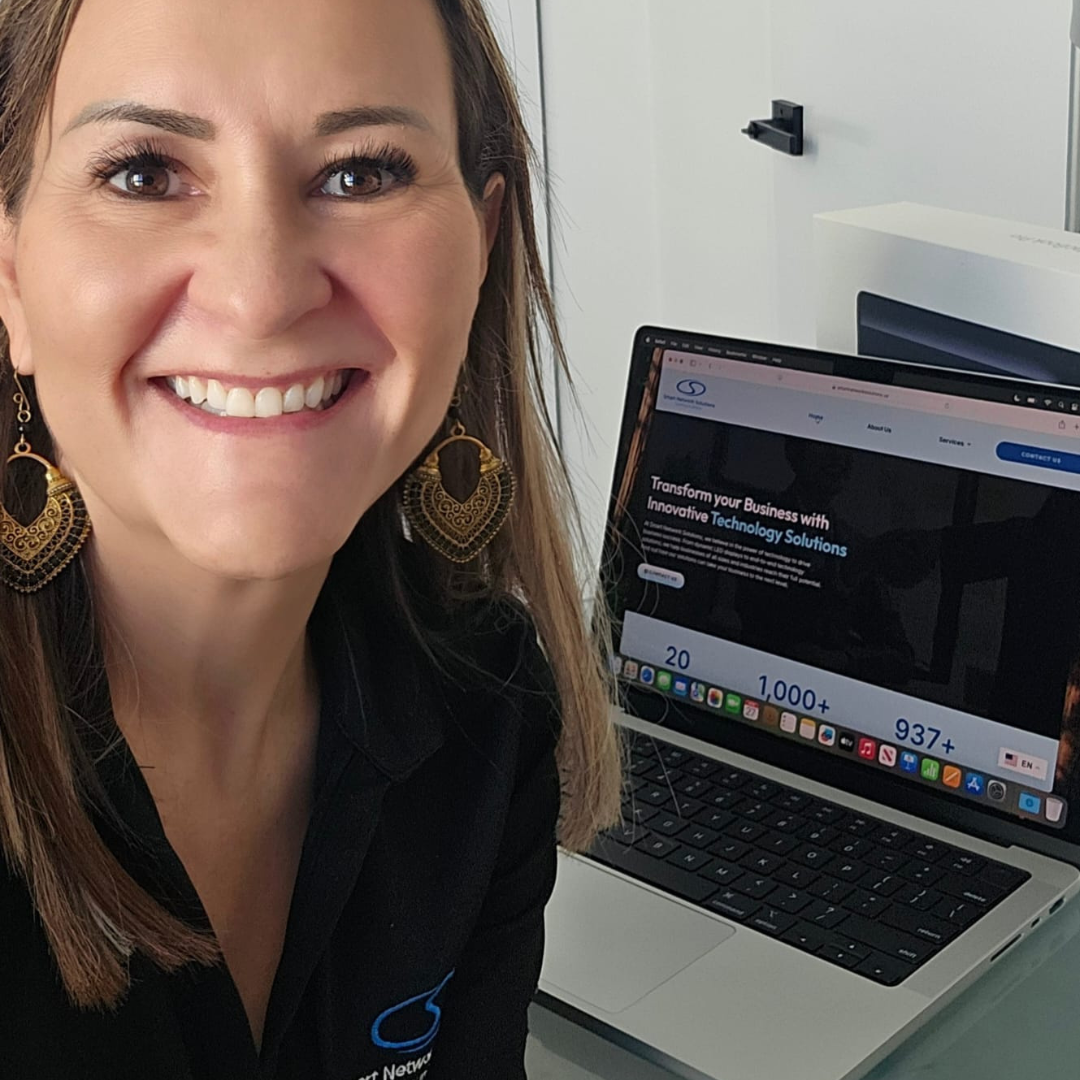 Woman smiles in front of her laptop purchased via Miami Open for business.